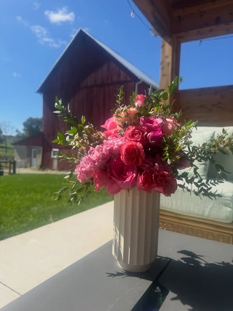 Garden roses and seasonal flowers in a white vase outside the farmhouse