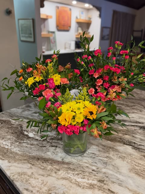 Bright pink, orange and yellow floral arrangements in the home studio